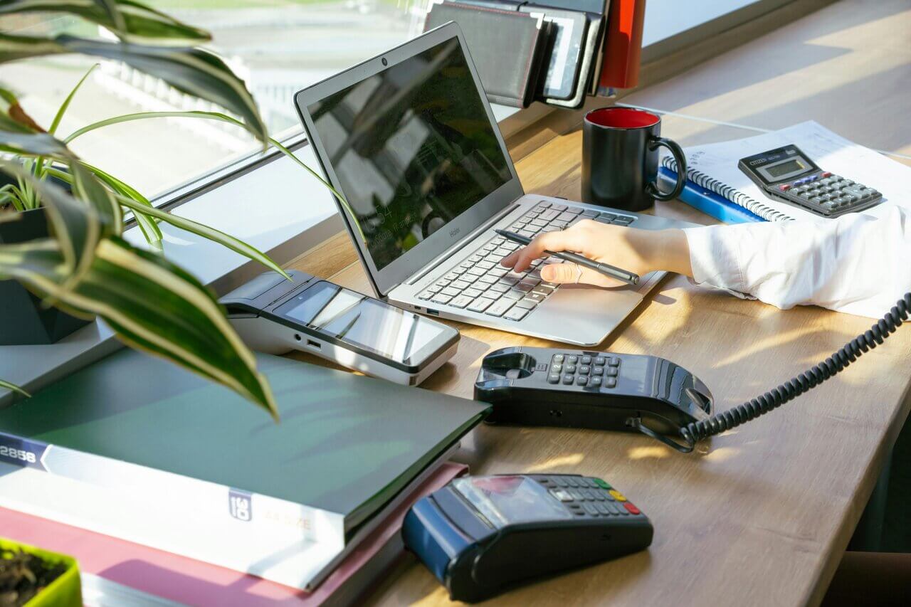 Desk top with laptop, phone and card machine