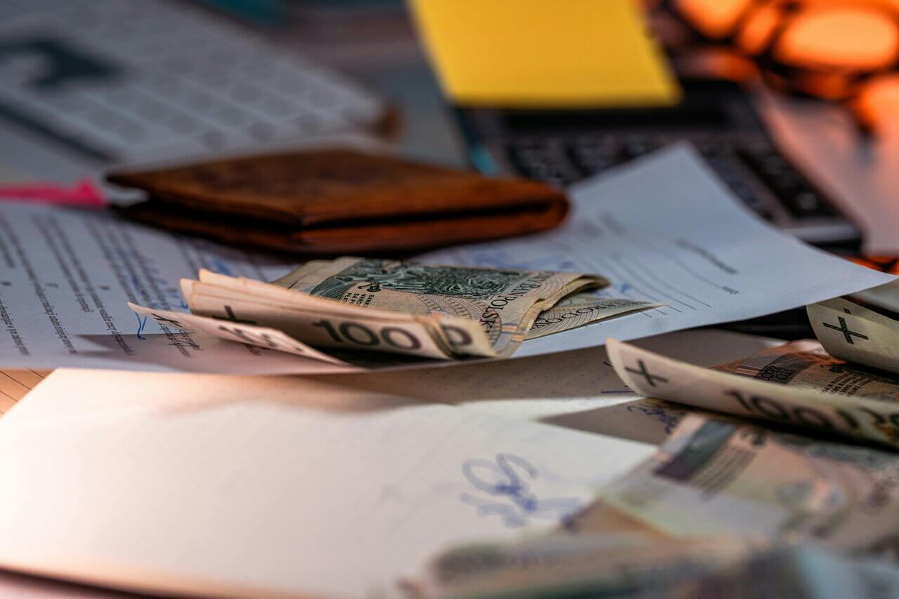 Close up of desk with documents and cash layed out